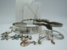 A small selection of silver and white metal jewellery including pendant, brooches, twist bangle,