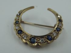 A 9ct gold crescent brooch having diamond and sapphire decoration, approx 3.1g