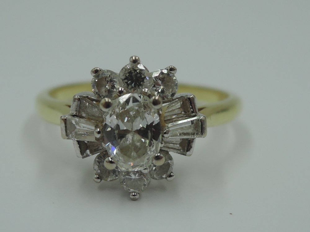 A lady's dress ring having a diamond cluster with central oval diamond surrounded by baguette and