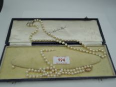 A knotted string of cultured pearls of even form having circular yellow metal box clasp stamped 333,