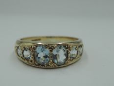 A 9ct gold band ring having six pave set topaz style stones, size N/O & approx 3g