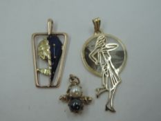 Three yellow metal pendants, including enamelled maiden's head, pearl duo and figure, one stamped