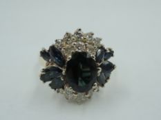 A sapphire and diamond oversized cluster ring having central sapphire, approx 1ct flanked by a