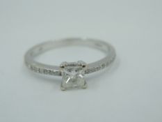 A princess cut diamond solitaire, approx 0.30ct in a four claw mount to diamond chip set shoulders