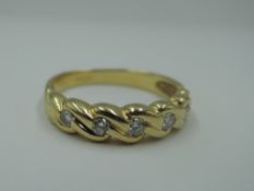 An 18ct gold band ring having five diamonds, total approx 0.25ct in a moulded mount, size L/M &