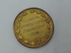 A 9ct gold medalion presented by Ulverston Grammar School 1936 for English Essay, approx 6.9g