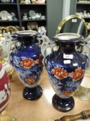 A pair of late 19th early 20th century vases, both tall and having handles, with floral pattern to