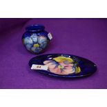 Two ceramics by Moorcroft in deep blue glazes a trinket dish and matching vase