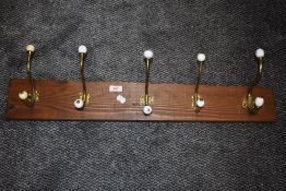 A set of brass and ceramic door or coat hooks