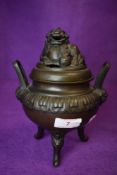 A vintage Chinese bronze three footed incense or pot pourri bowl with dog to lid.