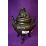 A vintage Chinese bronze three footed incense or pot pourri bowl with dog to lid.