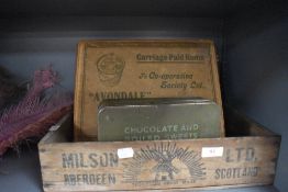 A selection of vintage advertising boxes including wooden crate