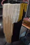 A collection of vintage and antique shawls and aprons, including deeply fringed cream silk shawl and
