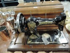 A vintage hand cranked Jones sewing machine with fitted case