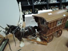 A vintage ceramic horse pulling wooden Romany caravan.