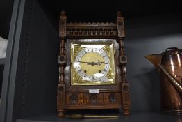 A large extensively carved Victorian oak bracket clock having gilt detailing to face.