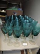 A large selection of wine cocktail and spirit glasses in a jade green with twist stems and etched