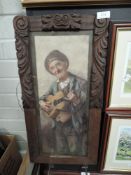 A print of a tramp playing guitar in carved oak frame