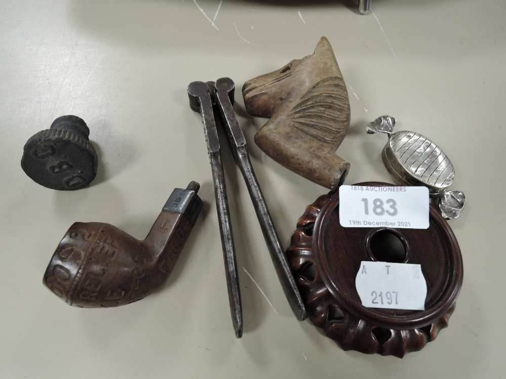 A selection of curios and trinkets including two pipe heads and small sweet style case