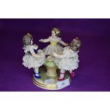 A figurine depicting three young girls.