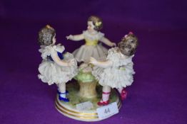 A figurine depicting three young girls.