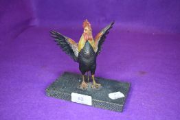 An early 20th century cold painted cockerel on mount.