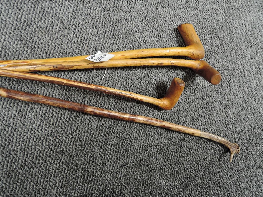 Four walking canes including antler handled example.