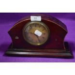 An early 20th century mantel clock having mahogany body and roman numerals to face.
