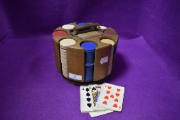 A Vintage rotating wooden poker chip caddy with cards and early plastic chips included.