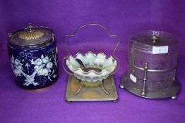 A striking cobalt blue ceramic biscuit barrel with floral pattern, a Vaseline glass condiment dish