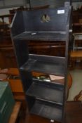A dark stained Arts and Crafts style narrow bookshelf