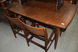 A vintage teak extending dining table and set of four chair frames (seats removed)