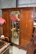 An Edwardian mahogany and inlaid mirror door wardrobe, width approx. 173cm
