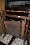 An early 20th Century firescreen having turned oak frame and tooled leather panel and strap work