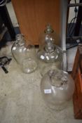 Four traditional glass demijohns