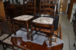 A Priory style dark oak dining table and set of four ladder back dining chairs