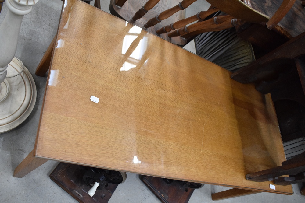 A vintage golden oak coffee table having glass protector top, approx. 110 x 53cm