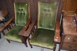 A pair of Arts and Crafts oak framed recliner chairs