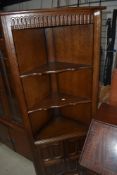 A dark stained Priory style corner shelf with cupboard under