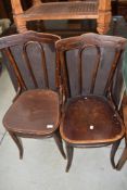 A pair of traditional bentwood chairs having ply seats, one with foliate detail