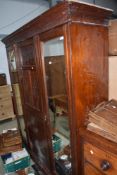 A Victorian mahogany mirror door wardrobe, triple section with centre press and drawer section,