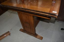 A 1930s golden oak drawer leaf dining table