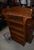 A golden oak open bookshelf in the stylised Arts and Crafts style , maximum width approx. 92cm