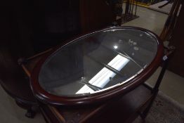 An early 20th Century mahogany framed oval wall mirror, hung in portrait orientation, approx 75 x
