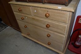 A traditional stripped pine chest of two over three drawers