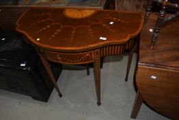An Edwardian mahogany fold over card table having drawer leg, with shaped top and Sheraton revival