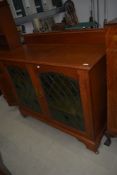 A traditional golden oak sideboard/cabinet in the Arts and Crafts style, having coloured and