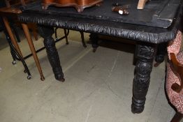 A Victorian dark stained wind out dining table having heavily carved frame