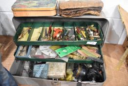 A Metal fishing tackle box containing a large quantity of lures/minnows, reel and a leather wallet