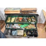 A Metal fishing tackle box containing a large quantity of lures/minnows, reel and a leather wallet